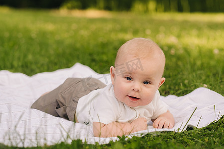 夏天，可爱快乐的小孩躺在户外草地上的毯子上