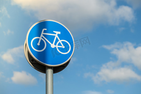 蓝色背景上描绘白色自行车的圆形路标，意味着蓝天背景下骑自行车者的强制性自行车道。