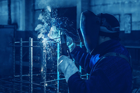 工人正在工厂或工业企业的金属结构上进行焊接工作