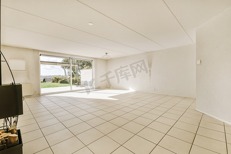 一间空荡荡的客厅，铺着白色瓷砖地板