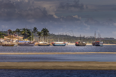 巴西巴伊亚日落时田园诗般的塞古罗港海滩与渔民船