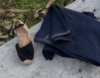 在田野石头上用手工刺绣织物制作的手工鞋的特写