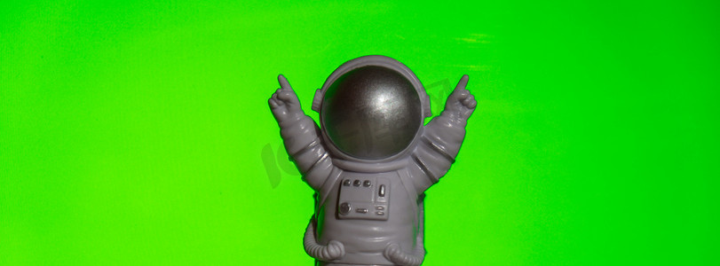 宇宙模板摄影照片_绿色色度键背景上的塑料玩具宇航员模板模拟复制空间。