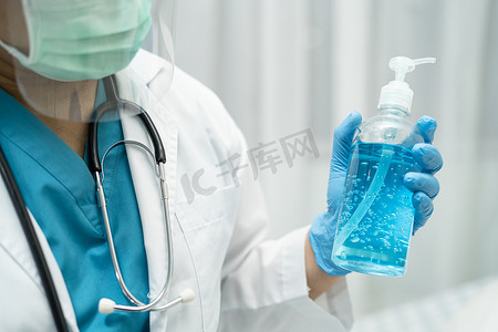 医生拿着蓝色酒精消毒剂凝胶为病人保护安全感染并杀死新型冠状病毒 Covid-19 病毒、细菌和细菌。