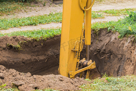 挖掘机的液压活塞在施工现场用工业铲斗深挖坑