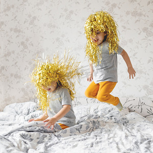 戴着亮黄色假发的双胞胎兄弟跳上床。