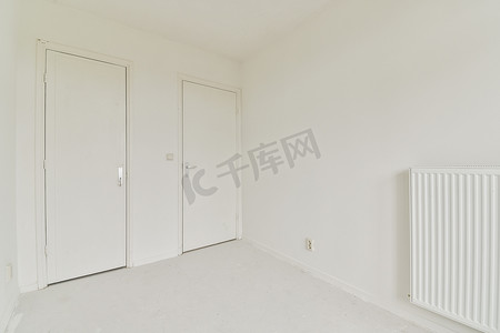 两个房间门摄影照片_一间有白色墙壁和两个壁橱门的卧室