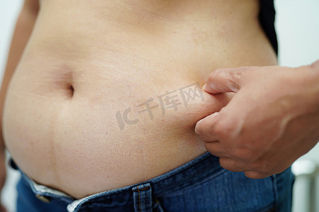 超重的亚洲女性用手挤压脂肪腹部大尺寸超重和肥胖。
