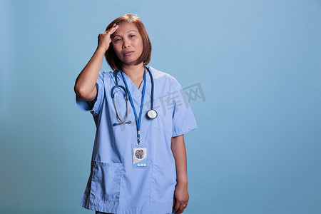 疼痛摄影照片_在体检期间从事疾病专业工作时有偏头痛的疲惫的医生护士
