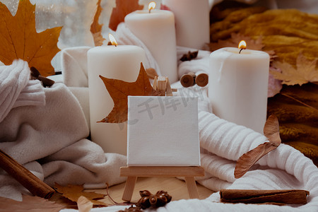空白的纸条复制空间，供您在审美氛围背景下的文字使用秋叶香料和蜡烛，在温暖的黄灯下的针织白色毛衣上。