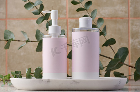 两瓶化妆品，白色背景上贴着粉色纸标签。