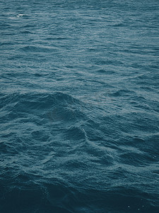 深蓝绿色水面的垂直视图与无尽深海中间的波浪。