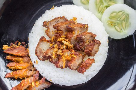 炒盘摄影照片_泰国菜炒猪肉配大蒜和黄瓜在黑盘平