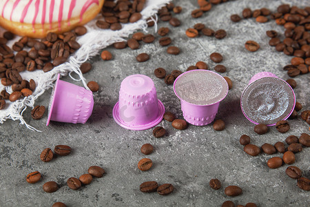 浓咖啡粉色塑料胶囊，配有箔纸、咖啡豆和甜甜甜圈