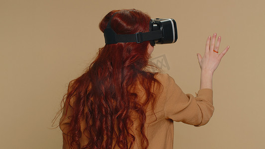 使用虚拟现实耳机头盔玩模拟游戏应用、观看视频内容的年轻女性