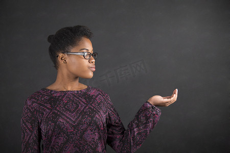 伸出手摄影照片_非洲妇女在黑板背景上伸出手