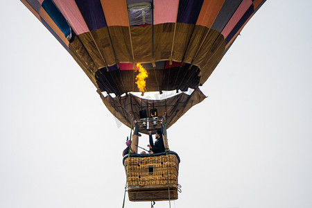 以喜马拉雅山脉为背景的柳条篮中用火加热空气的热气球篮的特写镜头，展示了库鲁马纳利山谷的这次冒险