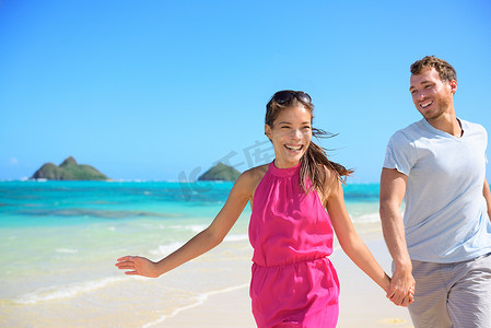 乐库摄影照片_快乐的情侣在海滩上跑步，在夏威夷玩得开心