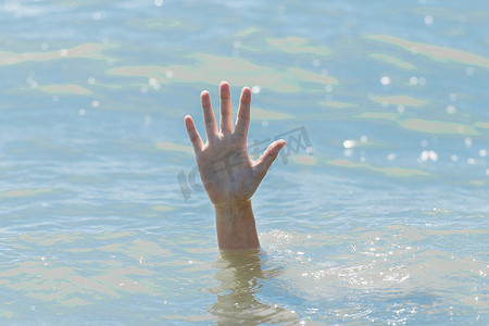 一只溺水女孩从水下伸出的手，在一次危险的游泳中帮助和紧急营救一个人，sos
