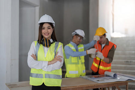 肖像、建筑工人和建筑，女工程师在现场工作时双臂交叉