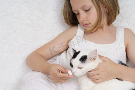 生病的少女给猫喂药​​。