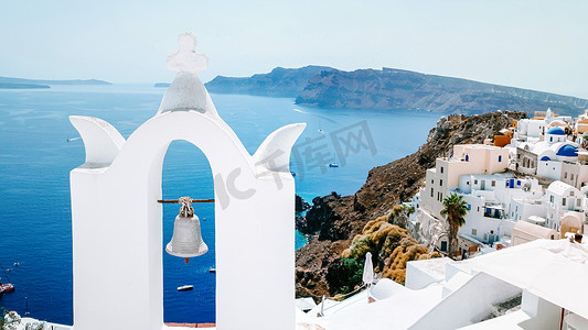 希腊圣托里尼岛日落时带蓝色圆顶和白色水洗房屋的伊亚圣托里尼岛