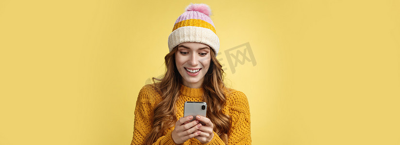 惊奇可爱的女孩收到好消息阅读激动人心的信息拿着智能手机睁大眼睛微笑手机显示屏玩很棒的手机游戏发短信发送图片寒假