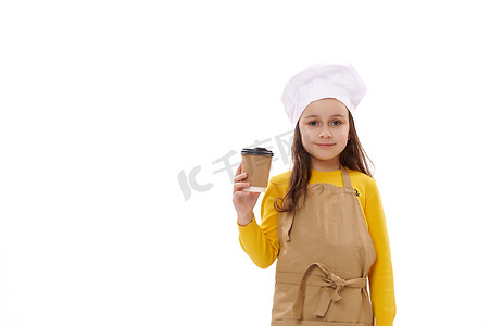 食堂外卖摄影照片_戴着厨师帽和厨房围裙的白人女孩，用一次性纸杯盛着外卖饮料。