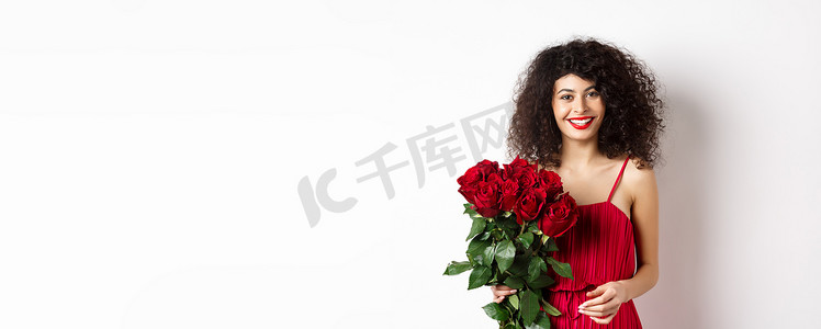 优雅的微笑女士，红唇和裙子，手捧玫瑰花束，看起来快乐，白色背景