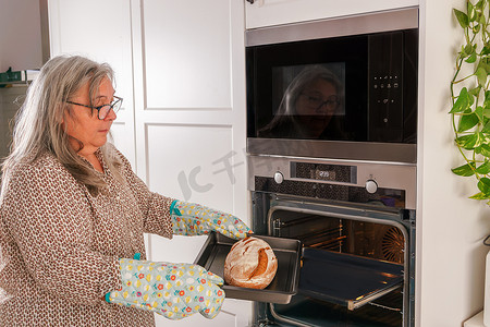 女人把面包放进烤箱