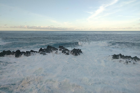 海浪拍打岩石的白色泡沫。