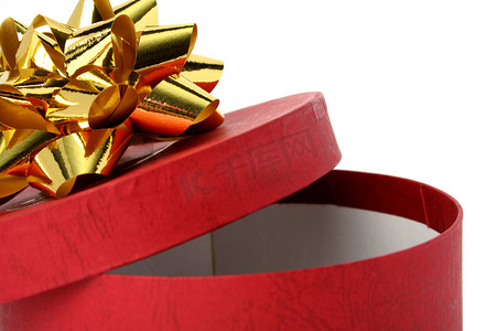 圣诞节打开礼盒摄影照片_带金色蝴蝶结的红色礼盒