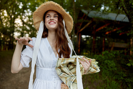 花纹免费摄影照片_自然界中一位笑容美丽的快乐女人的肖像，她戴着一顶柳条帽，手里拿着格子呢