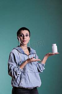 接受保健治疗后拿着一瓶止痛药对着镜头展示的女性肖像