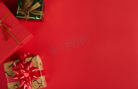 包装样机平铺图摄影照片_顶视图可爱的礼物和礼品盒为圣诞节和新年在红色背景与复制广告空间。