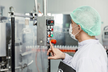 工作人员在卫生食品厂操作控制机器。