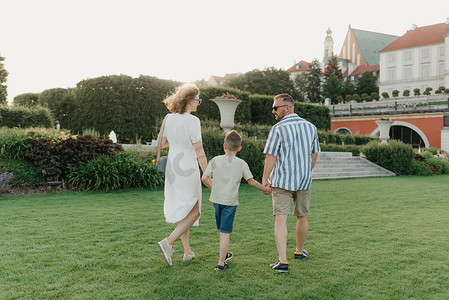 一家人在一座古老的欧洲小镇的宫殿花园里漫步。