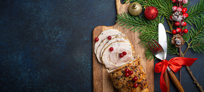 圣诞烤火腿切片配红浆果和节日装饰