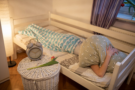 女人睡觉摄影照片_一个人把头藏在一个大枕头下。