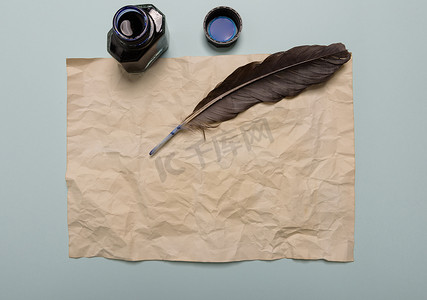 红色背景上的乌鸦羽毛、墨水瓶和旧黄纸。