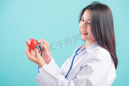 医生，手拿着红色的头，用听诊器检查她的心脏
