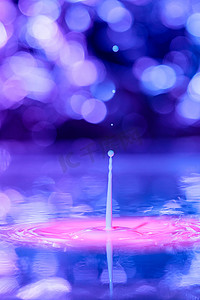 一滴落入具有蓝紫色背景的粘稠液体中。