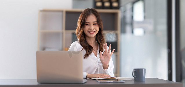 在办公室工作并通过笔记本电脑视频通话与业务伙伴讨论的亚洲女性，年轻的亚洲女商人是企业高管，创业公司高管。