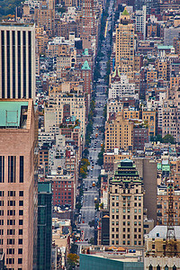 天空俯视摄影照片_从上方俯视纽约市长长的街道，两旁林立着柔和光线下的小摩天大楼