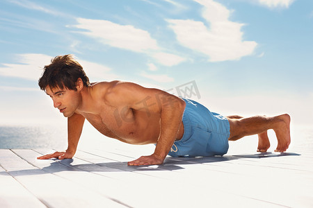 ups摄影照片_在阳光明媚的日子里，阳刚的男人在门廊上锻炼。