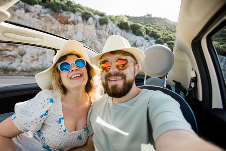 浪漫的情侣在海洋或海滩上租用敞篷车在智能手机相机上自拍，一起享受暑假，周末在海边休息的手机上拍照