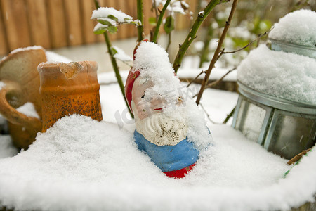 花园摄影照片_被雪覆盖的花园侏儒的特写视图