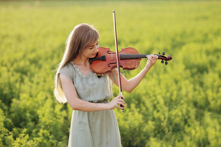 拉小提琴的头发松散的浪漫女人。