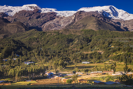 白雪皑皑的安第斯山脉日出时分的村庄和 Huascaran