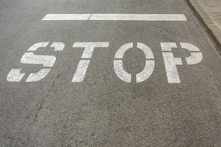不印章规则摄影照片_在沥青路面上标有道路标记“STOP”
